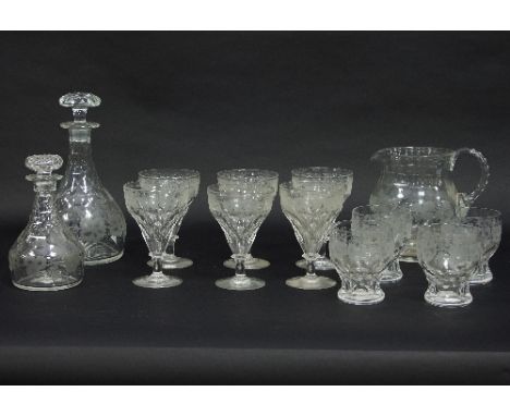 A quantity of vine leaf engraved glassware including a decanter and stopper, a small decanter and stopper, a jug, six rummers