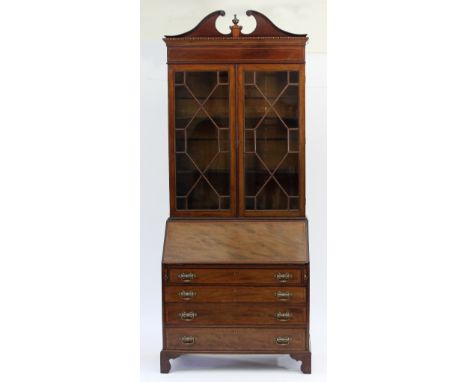 A Regency mahogany bureau bookcase, with satinwood banding and ebony stringing, the swan neck pediment above a pair of astrag