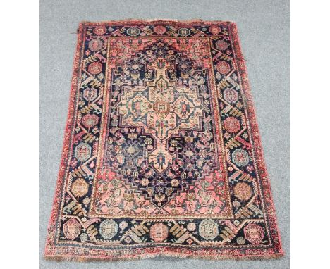 A Hamadan rug with central pink ground lozenge within a surround of boteh and other stylised designs, the blue ground border 