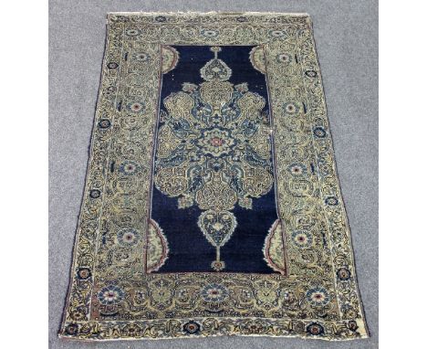 A Kirman rug with elaborate central medallion on a blue ground with half-round spandrels and floral figured border, 192cm x 1