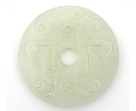 A Chinese white jade bi disc, carved with six stylised bird heads to one side the reverse with a repeating stylised pattern, 