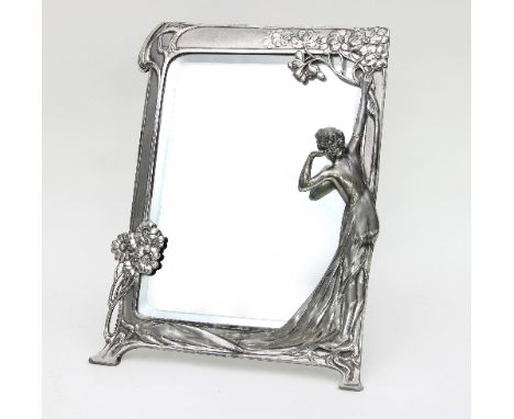 An Art Nouveau silver coloured metal framed mirror, modelled with a maiden under a flowering tree with blossom and stylised s