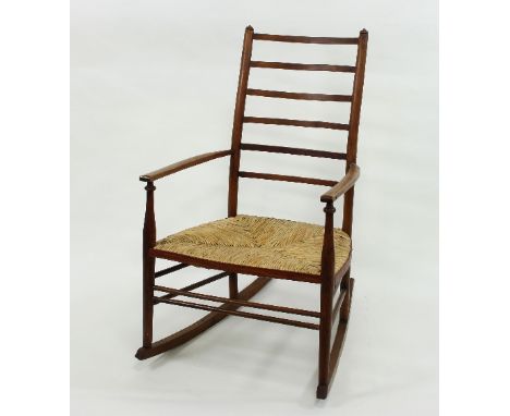 An Arts and Crafts style ladder back rocking chair with rush seat