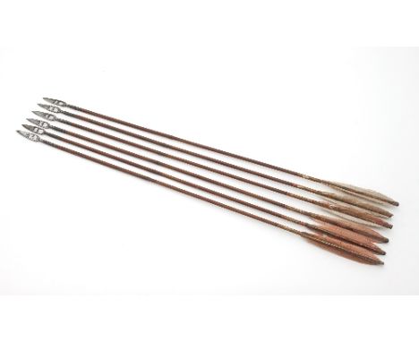 Six various burnished steel arrow heads with pierced decoration on later shafts, 77cm long