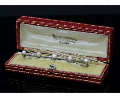 Boucheron: a natural pearl bar brooch, the row of five graduated pearls to a platinum bar signed Boucheron, Paris, 7cm long, 