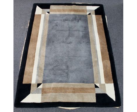 A mid 20th Century rug with geometric design in the Art Deco style, in blue/grey, beige, brown and black, 274cm x 188cm/see i