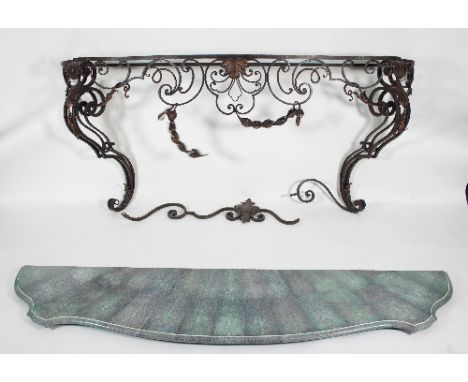 A wrought iron console table, the scrolling supports set with husk swags with a faux green shagreen shaped top, 198cm wide x 