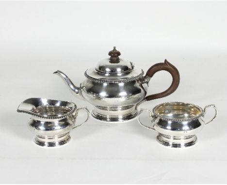 A bachelor's silver tea set, London 1928-29, comprising a teapot, jug and sugar basin, each of circular form with gadrooned r