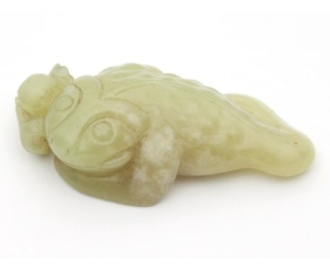 A Chinese yellow jade carving of a toad and pomegranate, 5.2cm long