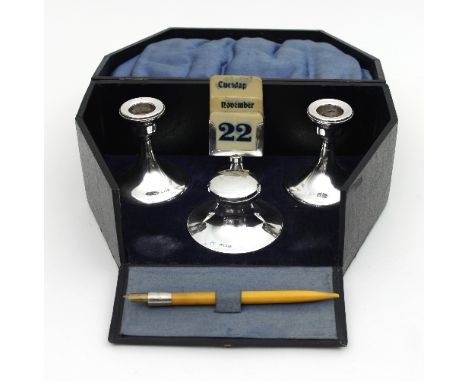 A silver desk set, Marson & Jones, Birmingham 1922/1923, comprising calendar with ivorine labels, pair of desk candlesticks a