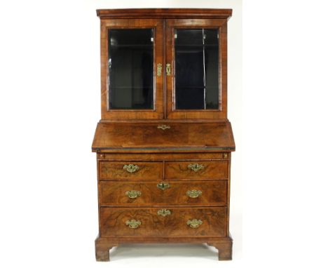 A walnut bureau bookcase with moulded cornice, the bureau with fitted interior above two long and two short drawers on bracke