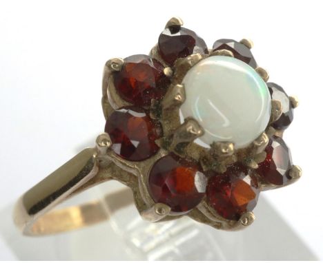 9ct gold flower ring set with garnets and a central opal, size K/L, 2.2g. P&amp;P Group 1 (£14+VAT for the first lot and £1+V