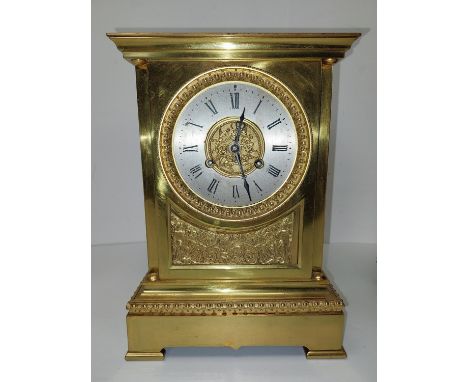 An early 20th century brass mantle clock with relief scrolling foliate and knight design, classical form to the base. H.27 W.
