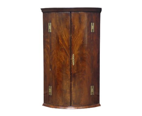 George lll mahogany bow front corner cupboard with moulded cornice above a pair of crossbanded matched curl veneer doors with