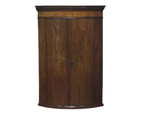 Georgian mahogany bow front corner cupboard, two bowed doors enclosing three shelves and two small drawers, W76cm, H110cm Con