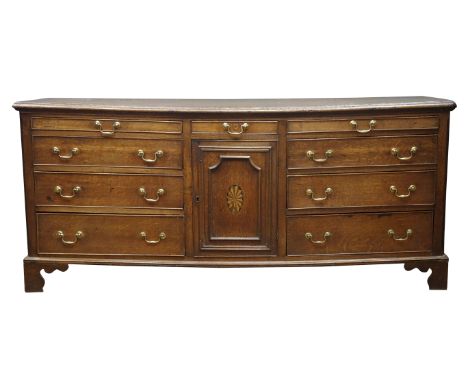 George III Lancashire oak dresser base, moulded top above nine drawers and cupboard door inlaid with fan, on bracket feet, W1