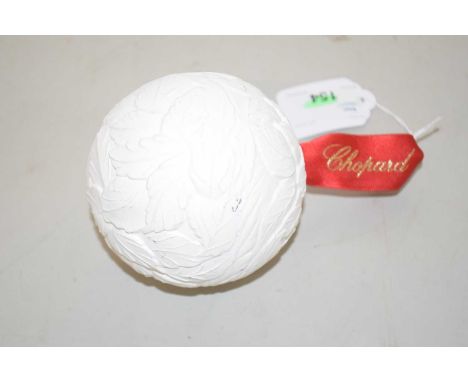 A Chopard Christmas bauble, relief moulded white ceramic with red branded ribbon, 9cm diameter