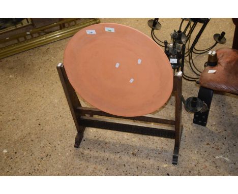 An unusual fire screen formed from a terracotta charger on an oak frame
