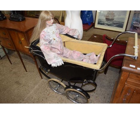 A vintage black pram together with a large porcelain body doll
