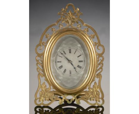 A FRENCH  GILT BRASS STRUT CLOCK, LATE 19TH C  the engine turned and silvered oval dial in foliate engraved and pierced frame