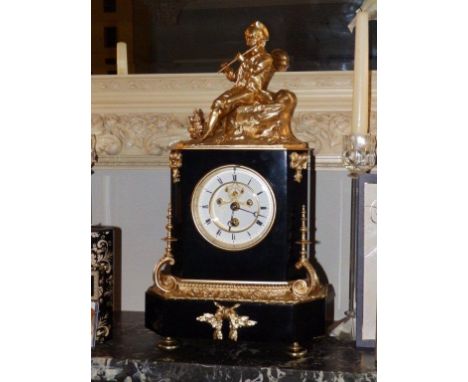 A 19thC French black slate mantel timepiece , with gilt metal figural surmount depicting a flautist, circular white enamelled