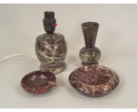 CORNISH SERPENTINE.
A red Cornish serpentine ash tray, 8cm, a small turned table lamp, 10cm & two other pieces.