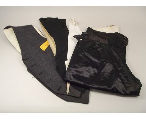 WAISTCOATS ETC.
An unworn, vintage tweed waistcoat, two other waistcoats & a pair of satin breeches.