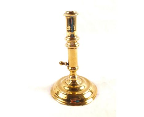 An early 18th Century side ejector seamed brass candlestick on circular base, 7 1/4" high