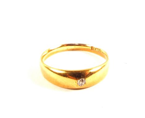 An 18ct gold band ring set with a small diamond, size R (wear to shank)