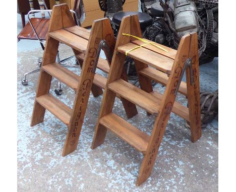 STEP LADDERS, a pair, marked with various champagne houses. (2)