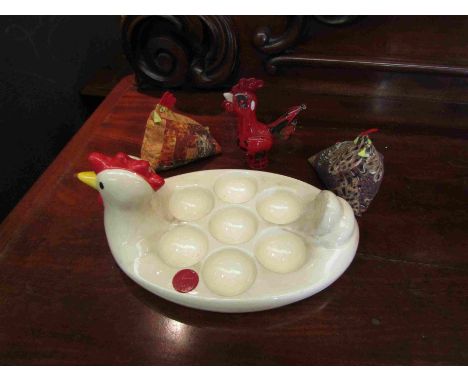 A Happy Hens ceramic egg holder, Langham glass Paul Miller cockerel and two hen pin cushions
