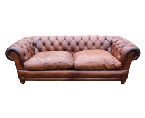 Good Quality 20thC Brown Leather Chesterfield 2 seater sofa with scroll arms above turned feet. 216cm in Length by 93cm in De