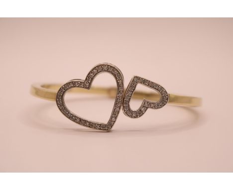 20thC 9ct Gold Twin Heart Design Diamond set bangle with sprung hinged fitting. 63mm in Diameter. 16.1g total weight 