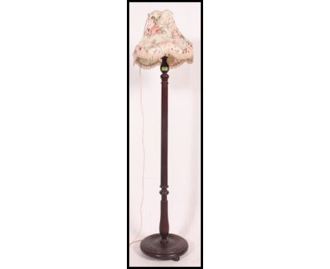 A 20th century standard lamp with terraced base, turned column and shade atop