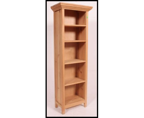 A tall contemporary stripped light pine upright bookcase cabinet with flared top and fixed shelves. H150 x W52 x D30cm 