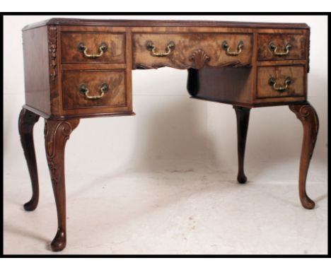 An early 20th century walnut writing desk, in George II style, shaped top, leather writing surface, one central drawer flanke