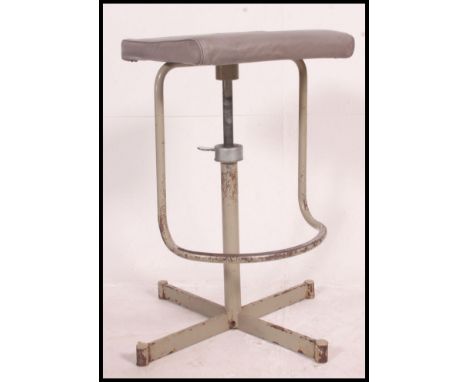 A superb vintage industrial machinists factory stool with adjustable height and unusual footrest. Grey vinyl seat.