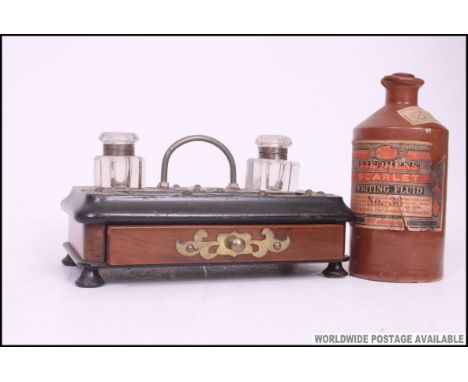 A Victorian ebonised mahogany desk tidy inkwell with twin glass wells and   carry handle to centre. Complete with a bottle of