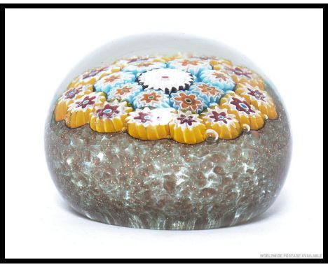 A vintage glass millifiori paperweight, no makers mark.   8cm wide