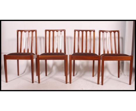 A set of 4 vintage mid century dining chairs being raised on tapered turned legs with bow railed back rests and overstuffed s