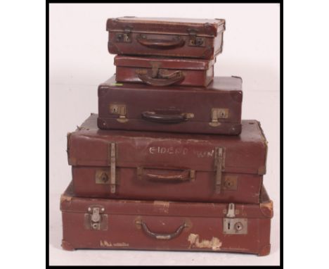 A collection of assorted sized vintage leather travel suitcases, some with monograms to top.