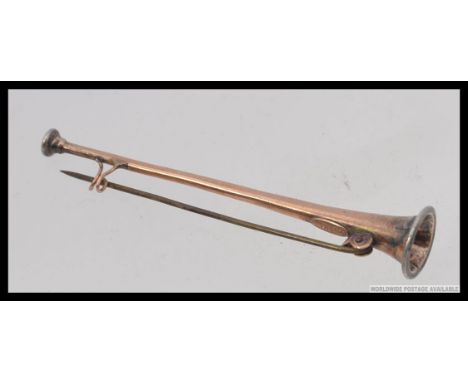 An early 20th century brooch in the form of a hunting horn / bugle. 9ct gold with silver ends. Marked to verso. With pin. Tot