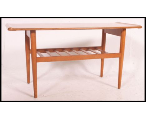 A mid century teak vintage / retro surf board style coffee table complete with magazine rack together with a retro yellow and