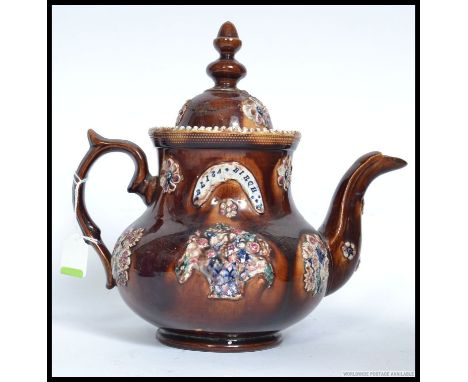 A large  Mearshaum  type  Bargeware majolica pottery teapot. Dated 1878 being of bulbous form  decorated with a treacle glaze