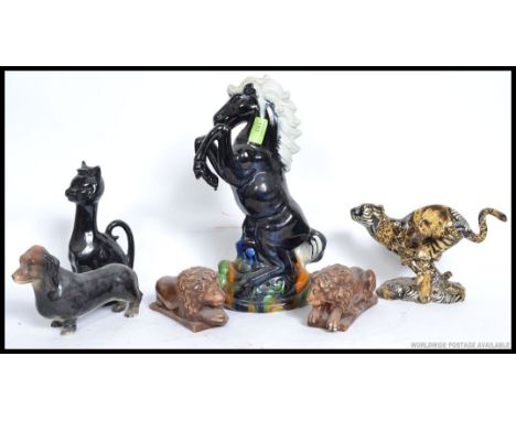 A collection of ceramics to include a ceramic study of a horse, Cheetah, cat, pair of lions etc please see images