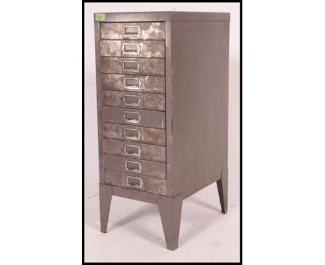 A vintage mid century industrial upright metal ten short drawer filing cabinet, shaped supports having notation slides and lo