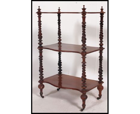 A Victorian walnut barleytwist 3 tier whatnot etagere. Raised on castors with shaped tiers having barley twist supports with 