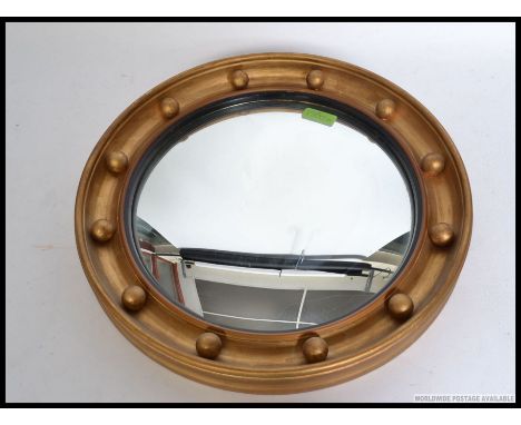 A mid century Regency revival circular convex mirror with ball finial borders,