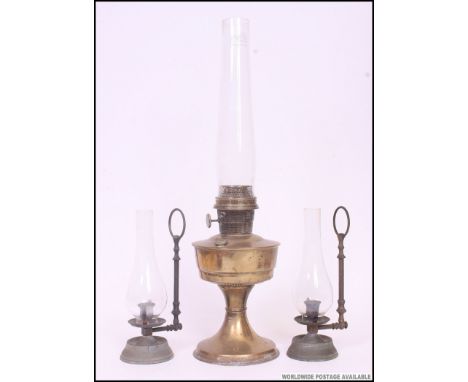 An early 20th century Super Aladdin brass oil lamp with flue. Together with a pair of cast metal oil lamps with wall mounts