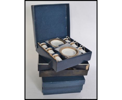 Three unused  cased coffee cans and saucers together with a Royal Worcester lidded blue and white cups in the original box